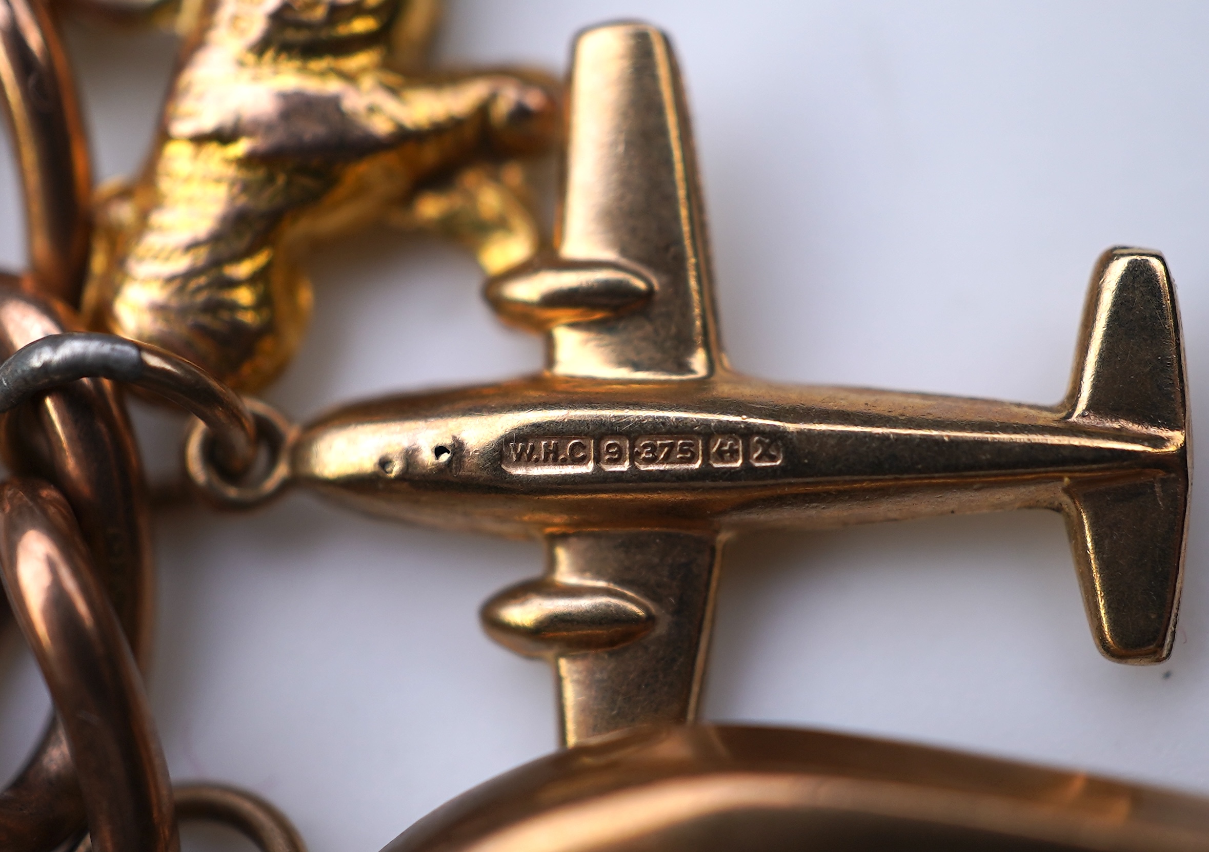 A gold charm bracelet, mid 20th century